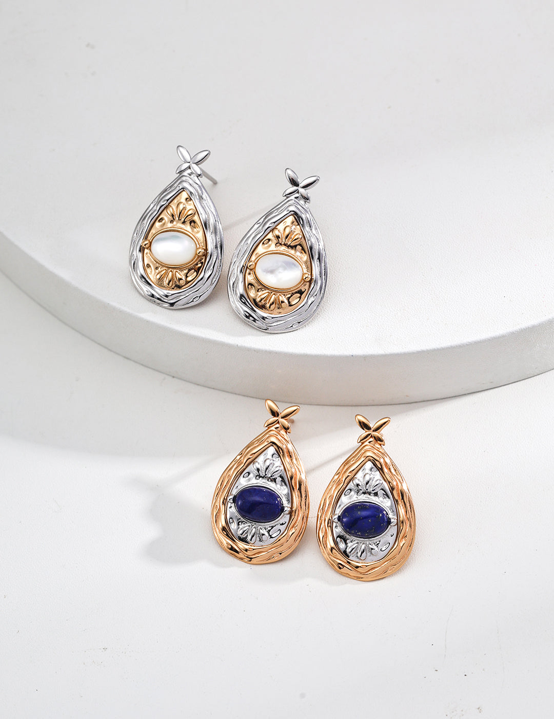 Teardrop-shaped earrings with gemstones on a white background